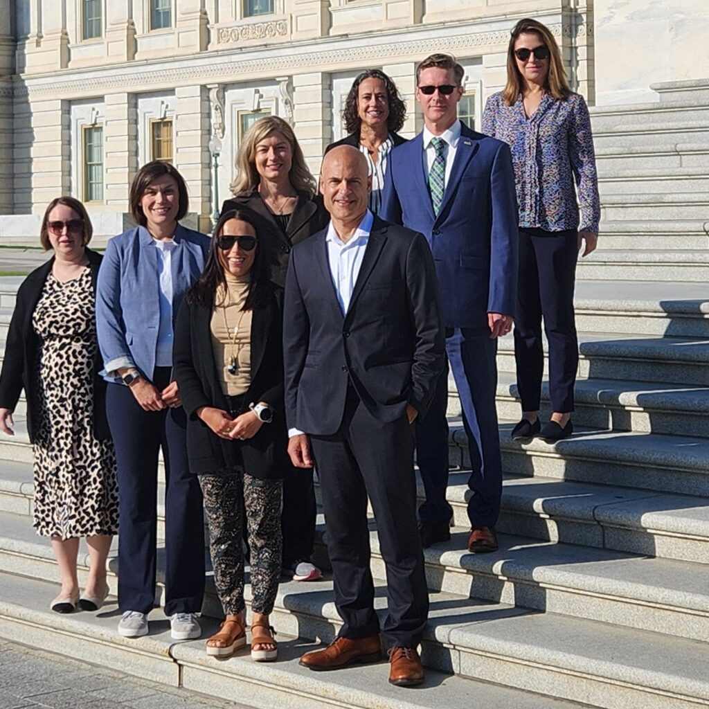 Scott Halpern and Joanna Hart pose with six other researchers on steps outside in Washington, DC.