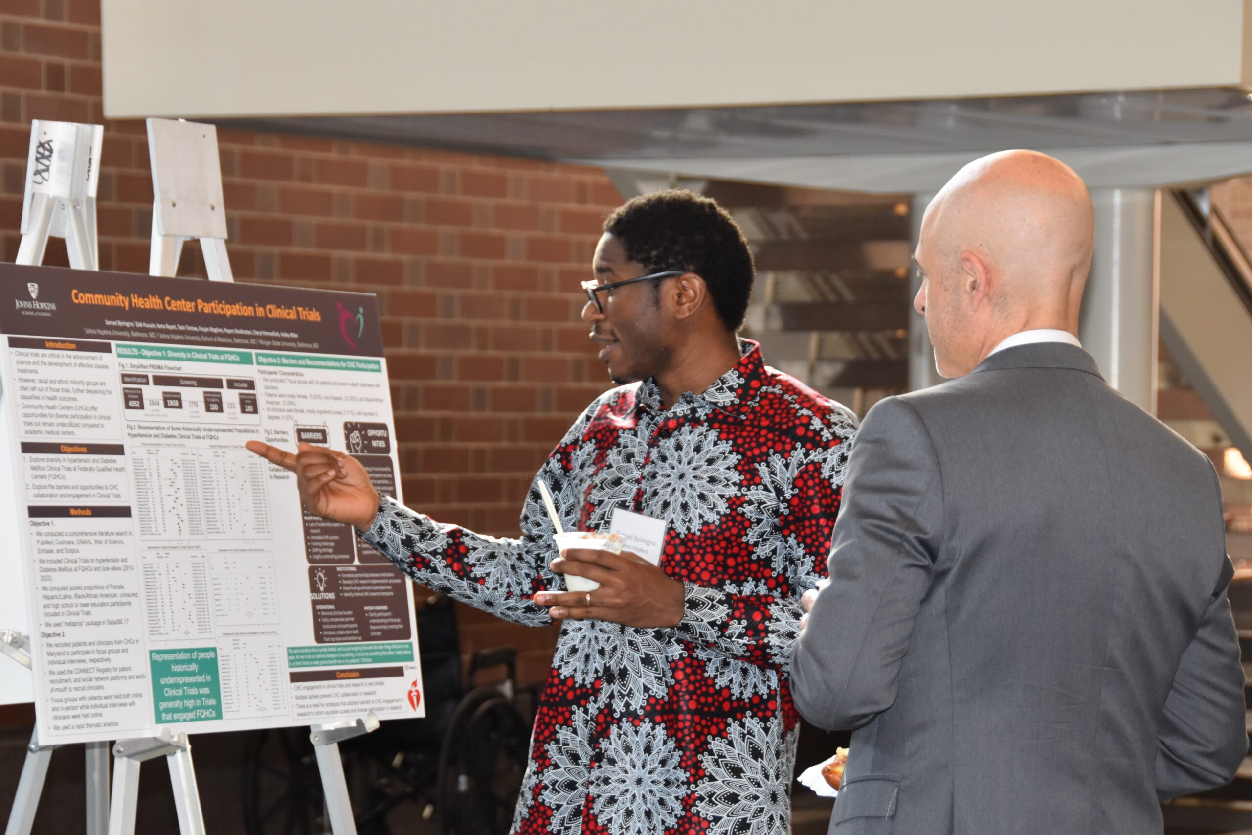 Samuel Byringiro presents his poster to Scott Halpern.