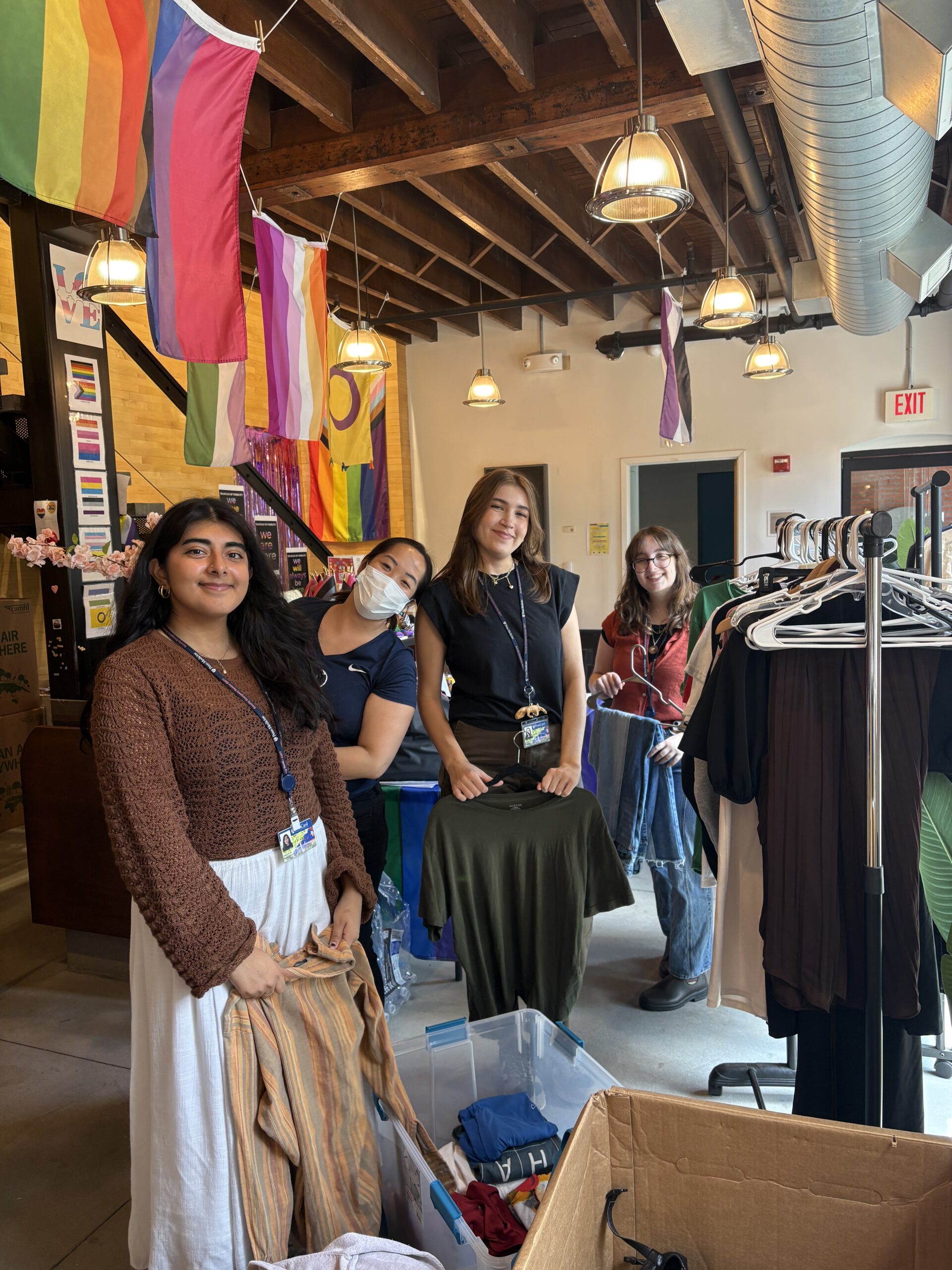 Paola Rosa, Dorothy Sheu, Alyssa Sliwa, and Emily Campbell sorting and hanging clothing.