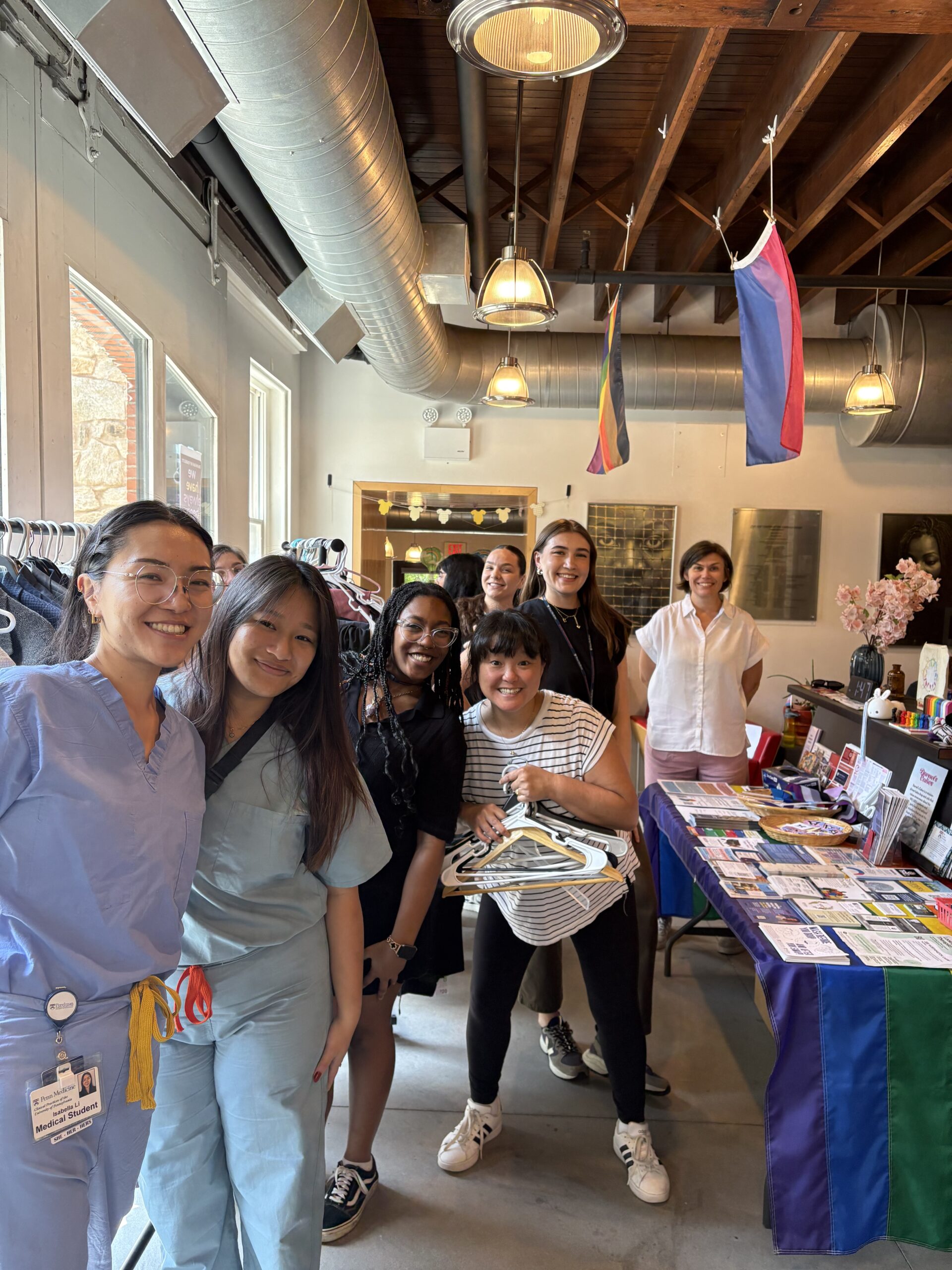 A group of volunteers pose in front of the clothing racks.